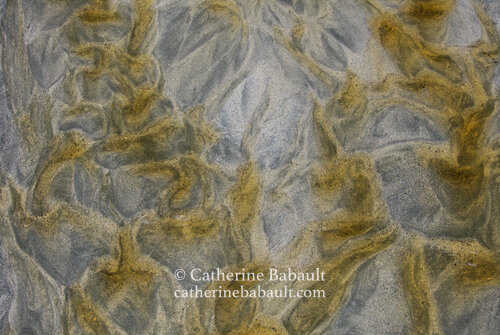 Sand sculpted by receiding water at low tide